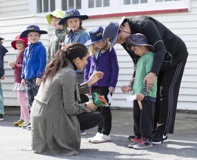 The Duchess of Sussex attempting to coax a smile from 5-year-old Joe Young while meeting with students from Houghton Valley School after their meeting with mental health project representatives at Maranui Cafe in Wellington. Photo: NZME