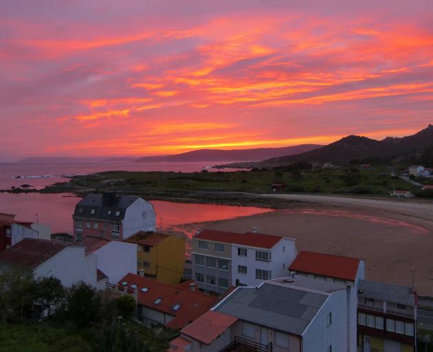 The sun sets on the fishing village of Camelle, Spain.