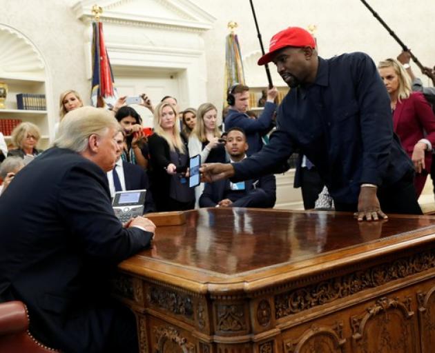 Rapper Kanye West shows President Trump his mobile phone during meeting in the Oval Office. Photo: Reuters