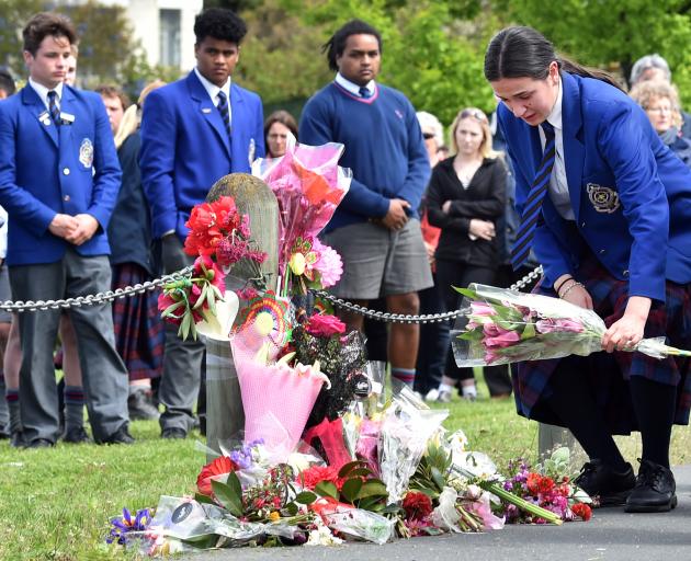 A St Kevin’s College pupil lays flowers at the scene. 