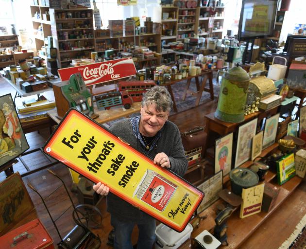 Proctor Auctions owner Ronald Proctor holds an advertising sign, which will be among 700 lots...