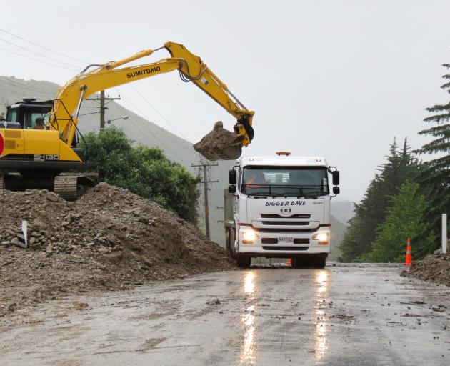 A digger clears debris from a culvert on State Highway 8, near the Roxburgh golf course early this morning, following heavy rain last night. Photo: Yvonne O'Hara