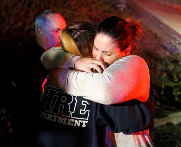 People comfort each other after a mass shooting at a bar in Thousand Oaks. Photo: Reuters