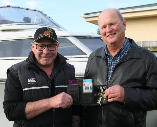 Ian Swain (left) and Greg Warden display the condition of Mr Swain's wallet and its contents...