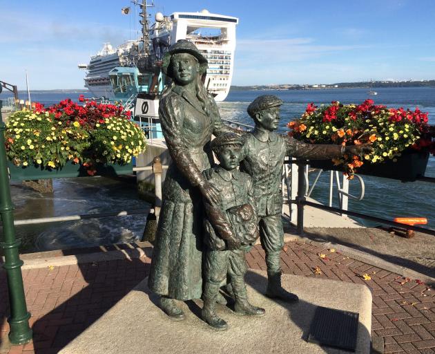 Diaspora memorial at the port of Cobh, Cork, with a modern cruise ship, Dawn Princess, leaving...