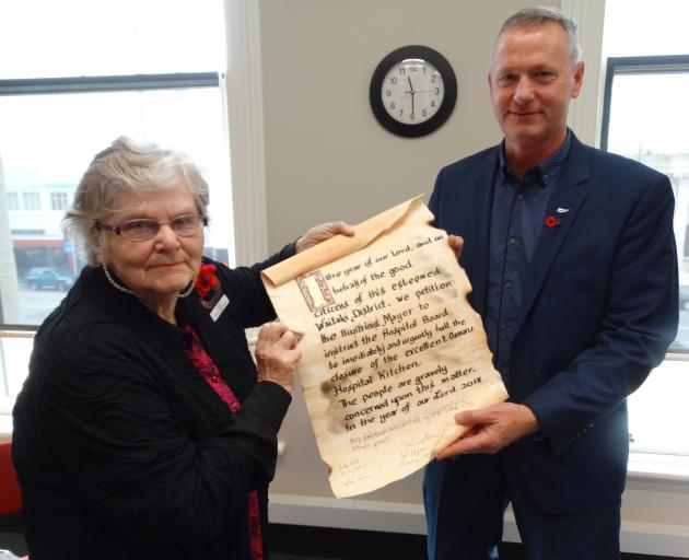 Save Our Hospital Kitchen founder Thelma Beer hands a petition opposed to the proposed closure of...