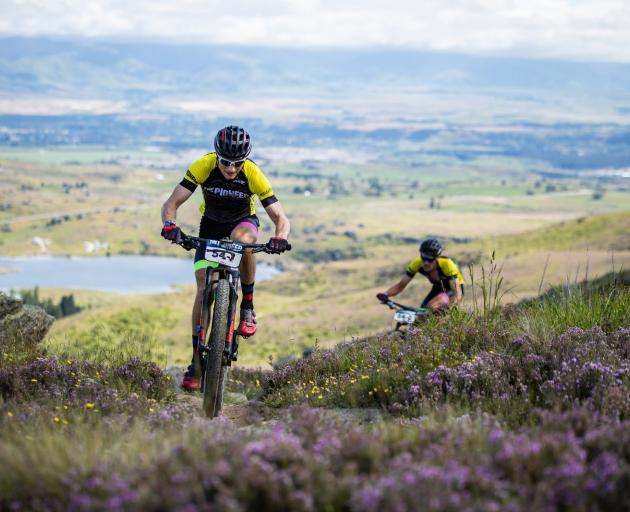 Tim Rush with Michael Vink in behind, climb Flat Top Hill, near Alexandra yesterday in the Pioneer race. Photo: Tim Bardsley-Smith