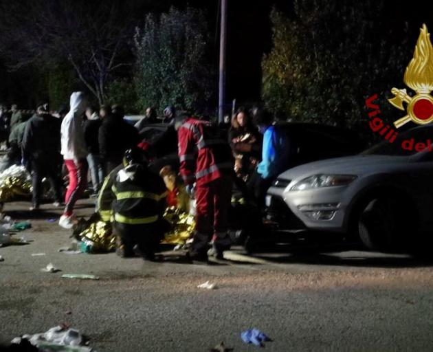 Emergency personnel attend to victims of a stampede at a nightclub in Corinaldo, near Ancona,...
