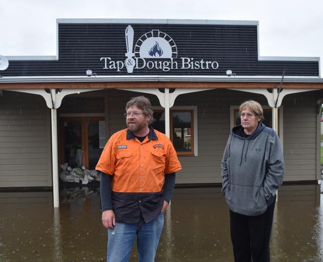 Owners Richard and Norma Emerson outside their flooded business at Middlemarch in November. Photo: Peter McIntosh