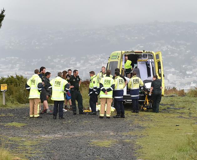 Emergency services and members of the public assist an injured mountain biker on Signal Hill this evening. Photo: Gregor Richardson