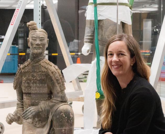 Te Papa curator Dr Rebecca Rice takes a look at one of the terracotta warriors being installed in an exhibition at Te Papa. Photo: Supplied