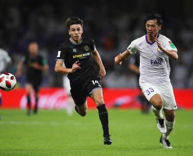 Jack-Henry Sinclair of Team Wellington and Tsukasa Shiotani of Al Ain chase the ball in their...