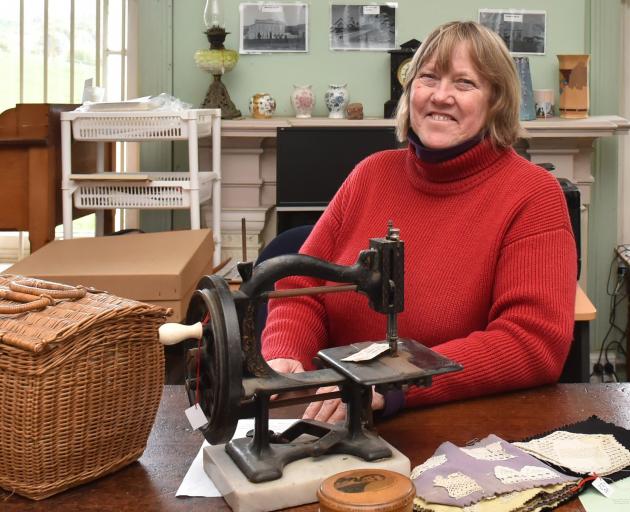 Museum curator Kay Lang with an 1870s sewing machine and equipment. Photo: Gregor Richardson