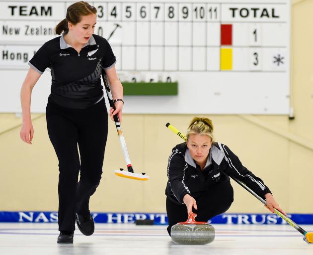 New Zealand women's skip Bridget Becker delivers her stone while team mate Jessica Smith looks on...