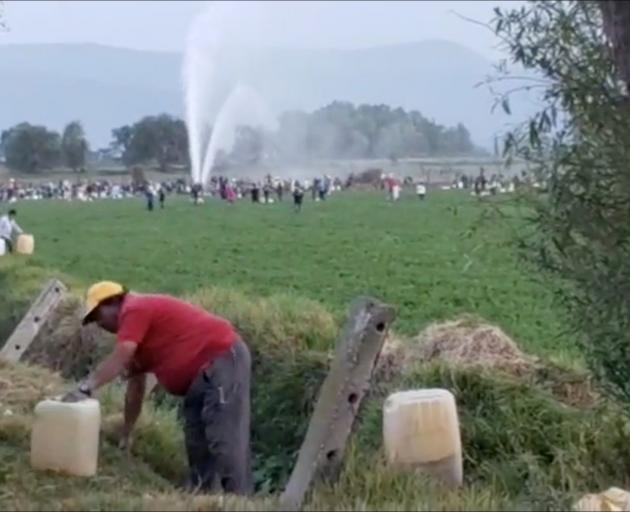 People gather at the site of a ruptured pipeline in the municipality of Tlahuelilpan, in Hidalgo....