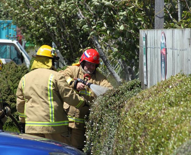Firefighters put out a small hedge fire in the Balclutha New World supermarket car park yesterday afternoon. Photo: John Cosgrove