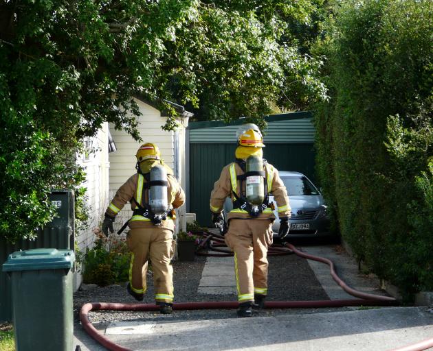 Firefighters enter a Balclutha property to assess the state of a solar system battery fire yesterday morning. Photo: Richard Davison