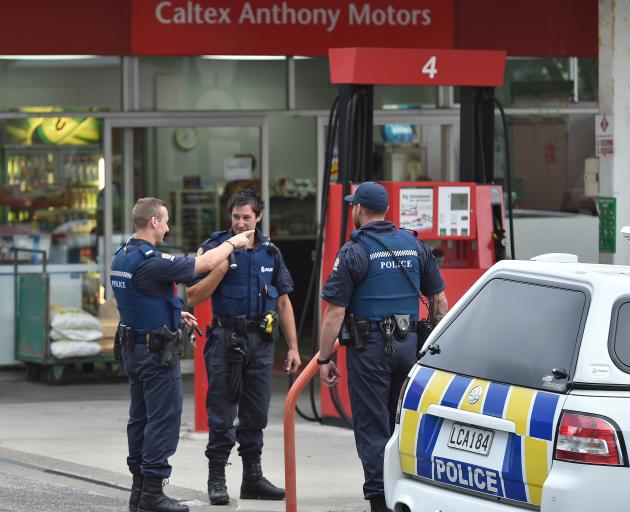Police officers talk on the forecourt of the Caltex service station in Taieri Rd last night after a man was arrested for allegedly attempting to rob the nearby On the Spot dairy. Photo: Gregor Richardson