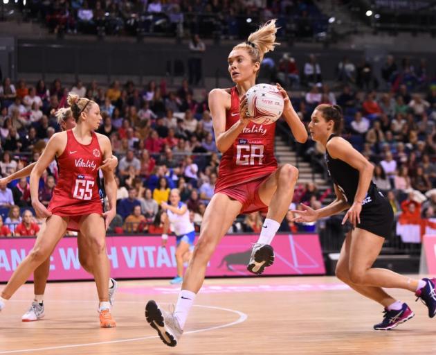 England's Helen Housby catches the ball as Silver Ferns defender Karin Burger trails her during...