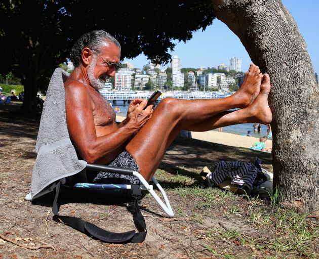Sydneysider Ed Sciberras relaxes at Red Leaf Beach, as temperatuers across the state have...