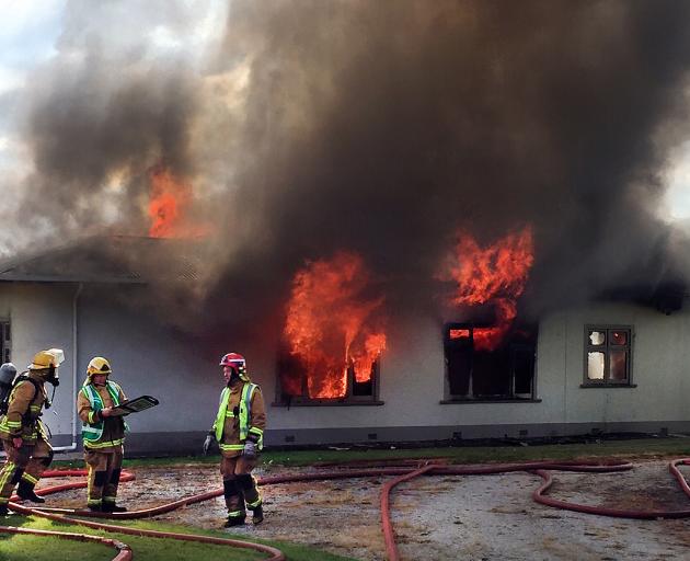 Fire crews work to control the fire raging though a four-bedroom homestead on Tokarahi-Tapui Rd. Photo: Supplied