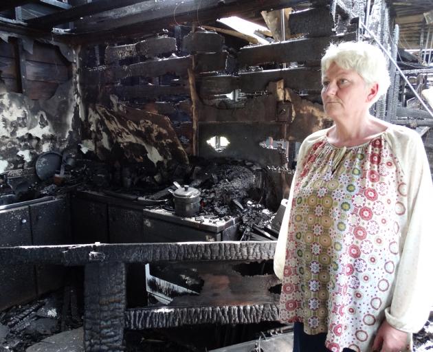 Louise Wainman assess damage to the Tokarahi-Tapui Rd home she rented with husband Ian that was...