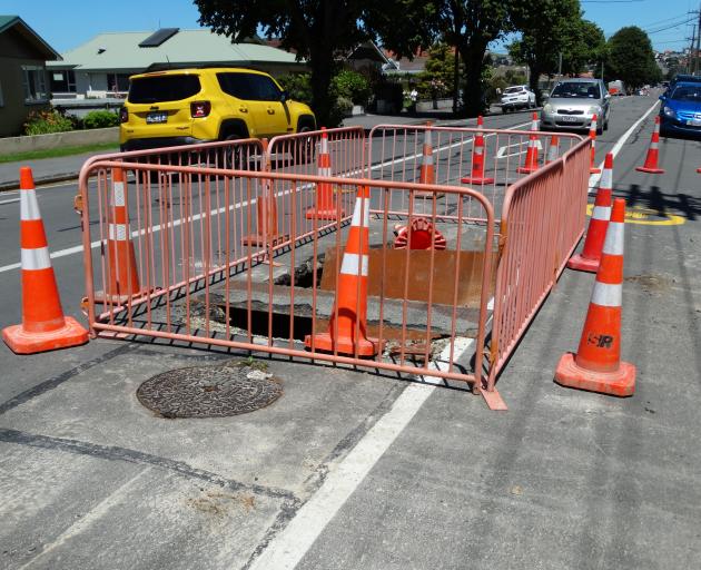 Motorists negotiate a fenced-off sinkhole in Reed St that opened up in late December. Work to...