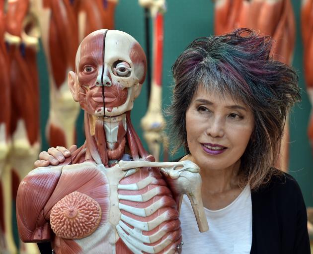 Thai forensic pathologist Porntip Rojanasunan inspects a plastic figure at the University of...