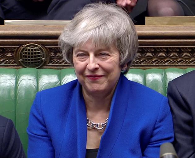 British Prime Minister Theresa May reacts as Jeremy Corbyn speaks, after she won a confidence...