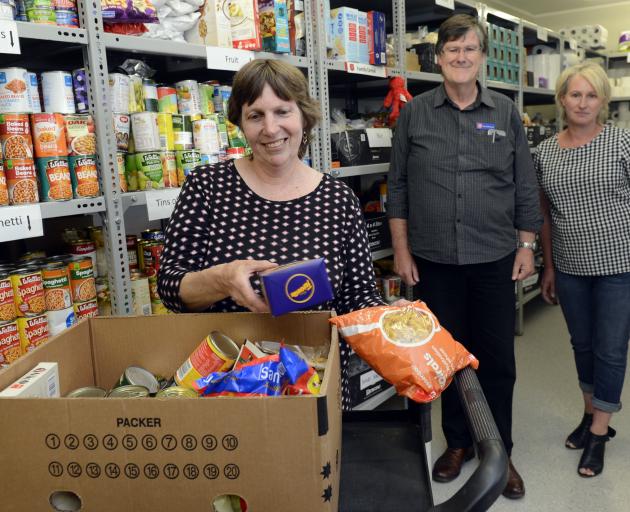  Salvation Army volunteer Donna Dunford packs groceries as community ministries manager David...