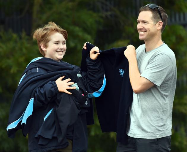 Leo Tucker (13) proudly holds his new King’s High School uniform, helped by his father, Gordon....