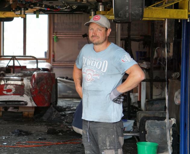 Andy Giles stands in front of a Rorstan Sports car, damaged in an early morning fire in Hawea Flat yesterday. Photo: Sean Nugent