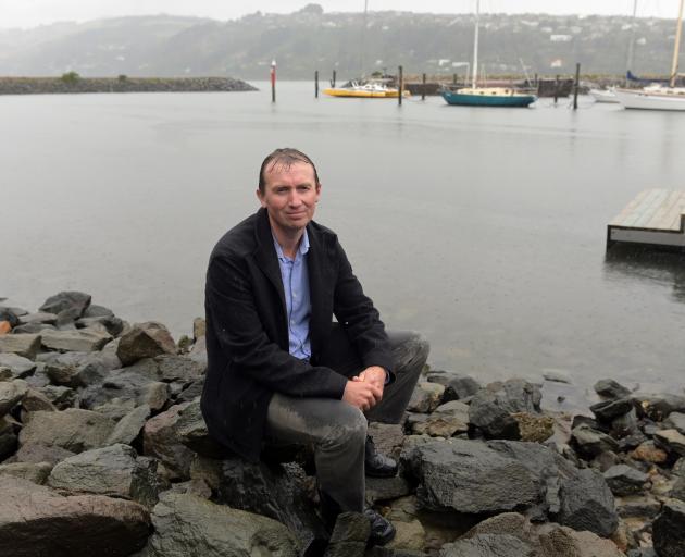 Chris Button sits beside Otago Harbour. PHOTO: LINDA ROBERTSON
