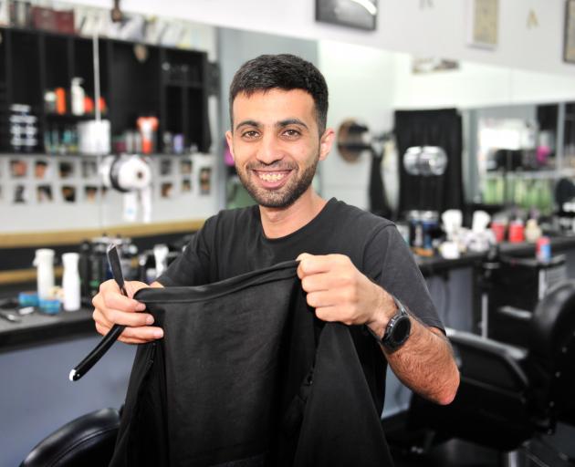 Mohammad Saad Aldeen prepares for a customer at his Princes Stbarbershop. Photo: Christine O'Connor