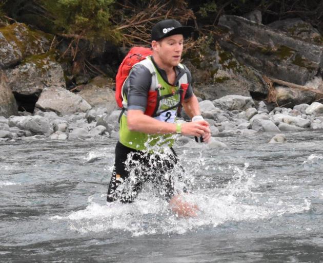 Dougal Allan crosses a stream during the mountain-running stage of the Longest Day at the...