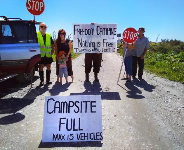 Kakapotahi and Pukekura residents picket the Beach Rd camp, at Waitaha, as they take action to limit the number of freedom campers parking up each night. Photo: Supplied