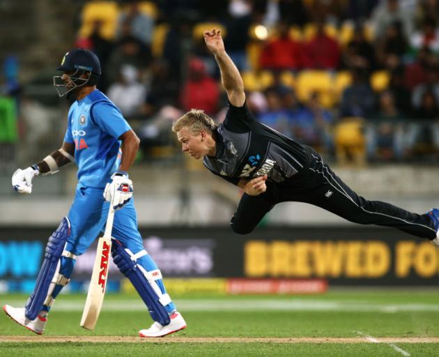 Scott Kuggeleijn of New Zealand bowls while Shikhar Dhawan of India looks on during game one of...