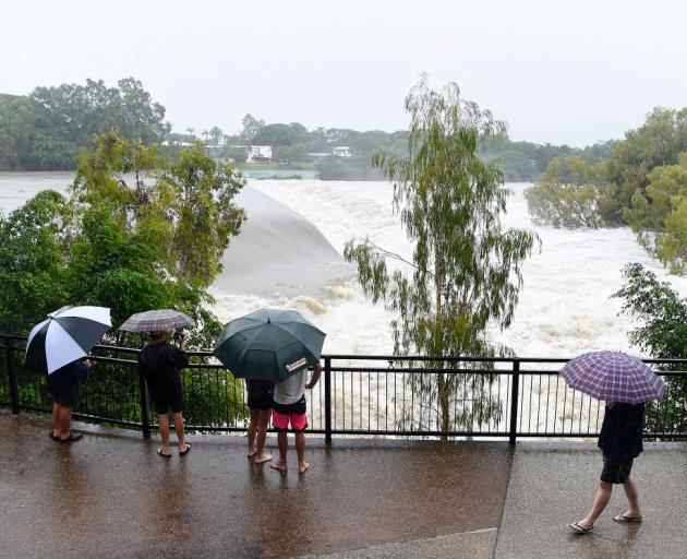 Townsville Residents watch the raging floodwaters of the Ross River in the suburb of Douglas in...