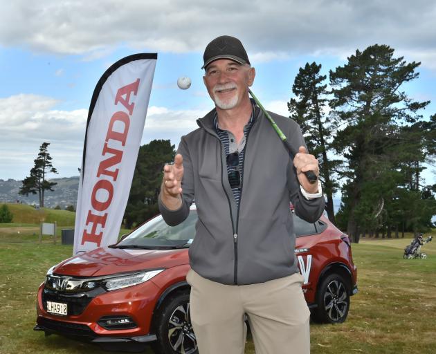 Golfer Giorgio Accorsi with the ball and club he used yesterday to win a new car which is behind...