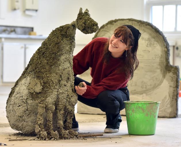 Jenny Hjertquist puts the finishing touches on one of her mythological dogs that will feature in...