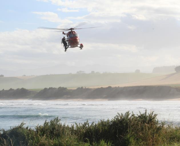 An Otago Rescue Helicopter circles back to land during a search for two missing men at Kakanui, yesterday evening. Photo: Hamish MacLean
