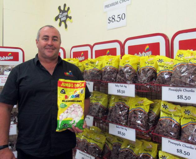 Rainbow Confectionery general manager Brent Baillie stands in front of bags filled with classic New Zealand lollies. Photo: Tyson Young