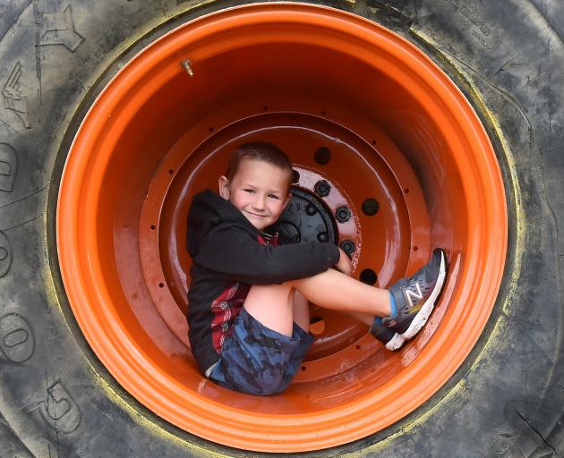 Mosgiel boy Byron Marshall-Sanders (5) curls up inside the wheel of the monster truck at the...