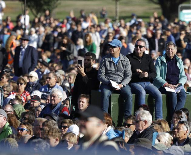 People listen during a National Remembrance Service in Hagley Park for the victims of the March...