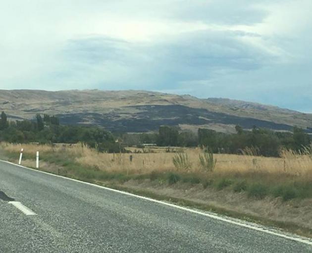 The dark patch on the hills shows were the fire raged overnight. Photo: George Block