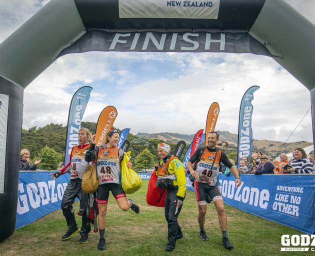 The winning foursome of (from left) Marcel Hagener, Emily Wilson and Simone Maier, all of Wanaka, and Chris Forne, of Queenstown, crosses the finish line at Akaroa yesterday to claim the Godzone adventure race. Photo: Alex Socci