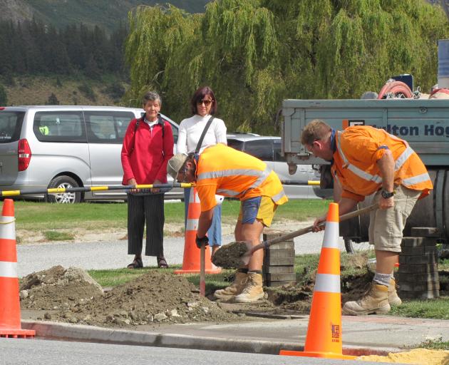 Wanaka residents Loris King (left) and Liz Hall watch as Fulton Hogan kerb and channel operations...