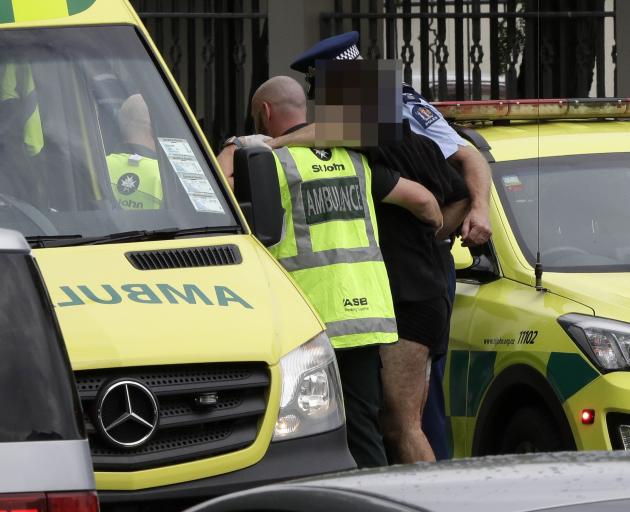 Police and ambulance staff help a wounded man from outside a mosque in central Christchurch. Photo: AP