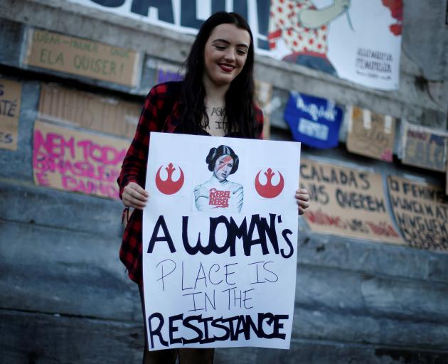 A woman holds a banner during a gathering to mark International Women's Day in Lisbon, Portugal....