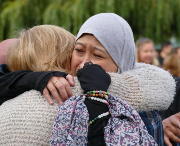 Maznab Abu Assan is embraced by Christine Adams, both of Queenstown, at the end of a candlelight vigil last night  Photo: Tracey Roxburgh